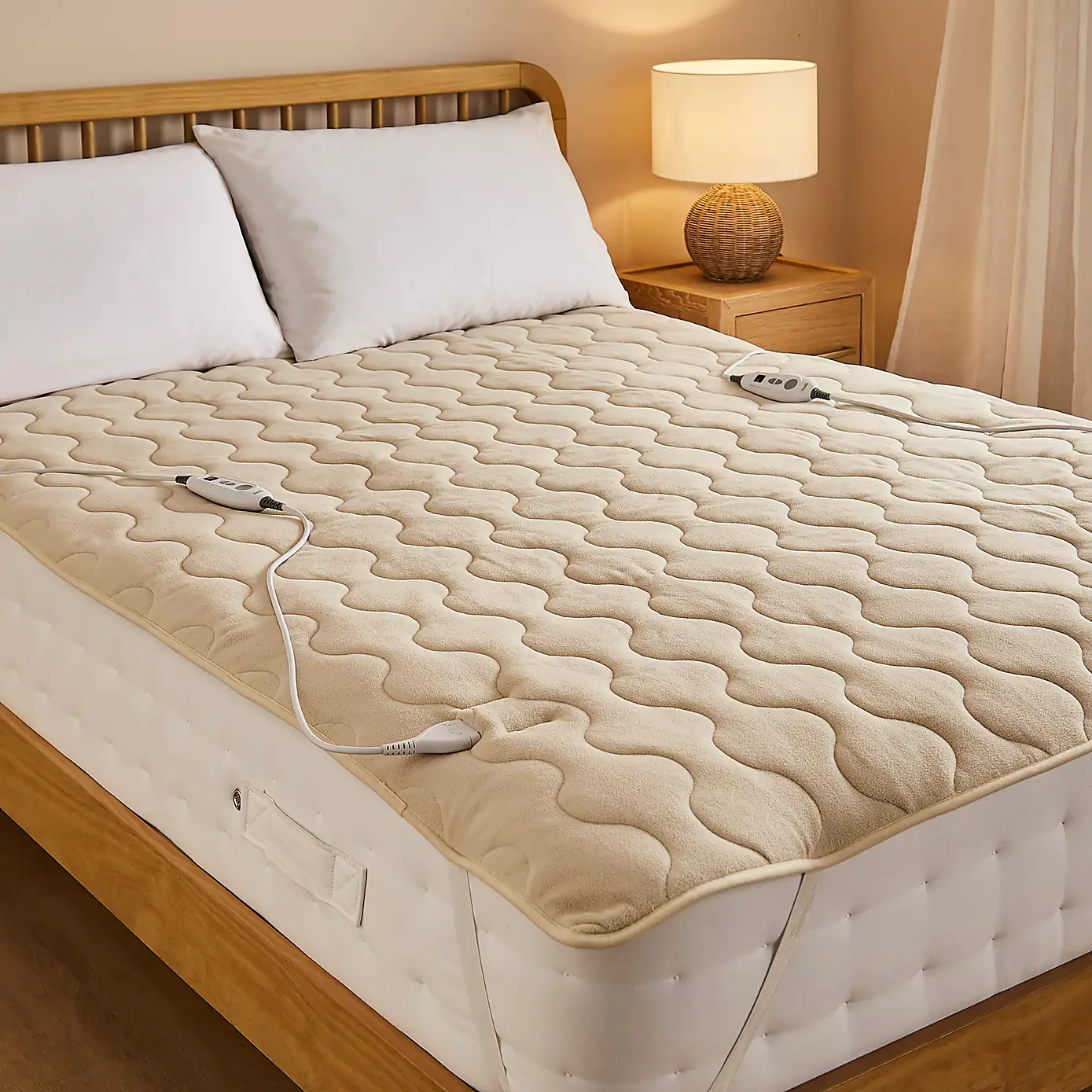 Electric heated blanket fitted on a bed with dual controllers